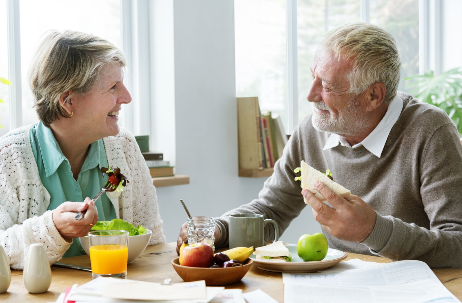 A senior man and woman sitting at a table enjoying a meal