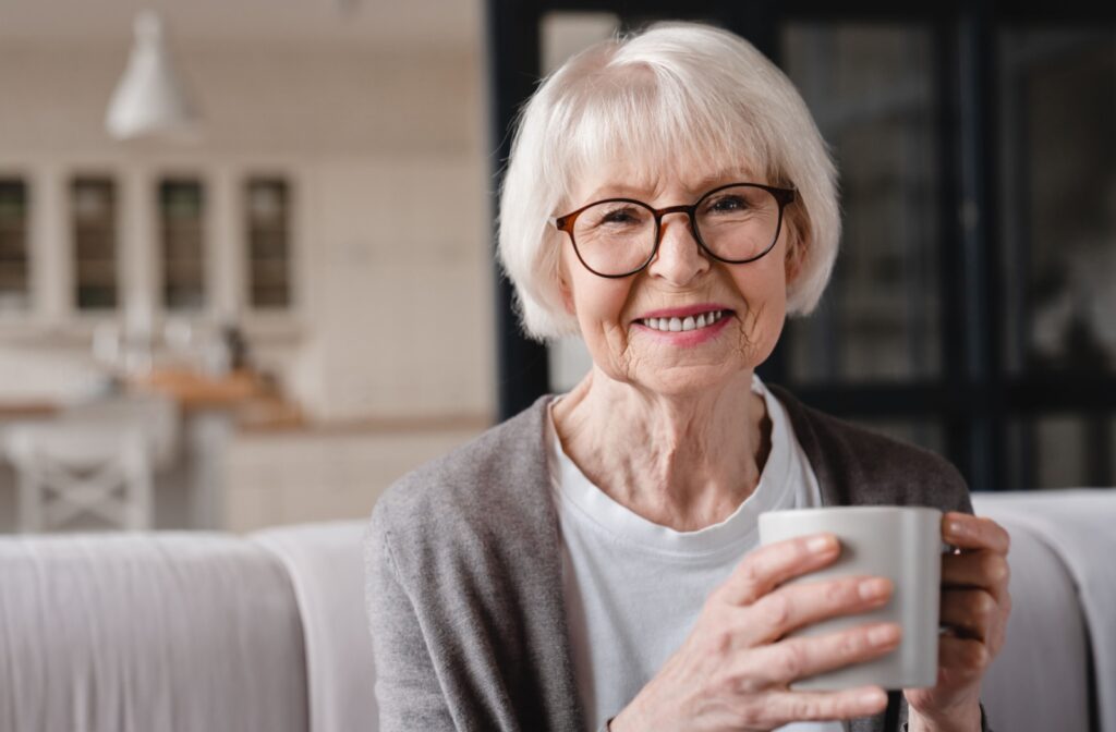 A senior woman holding a coffee mug and smiling