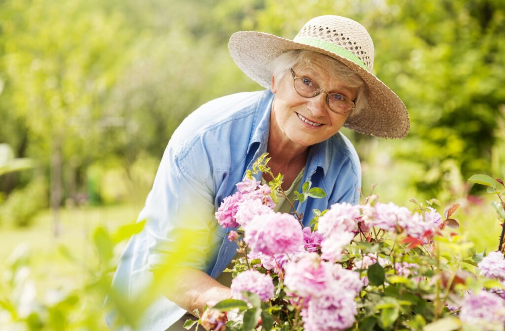 A senior woman tending to the flowers in her garden.