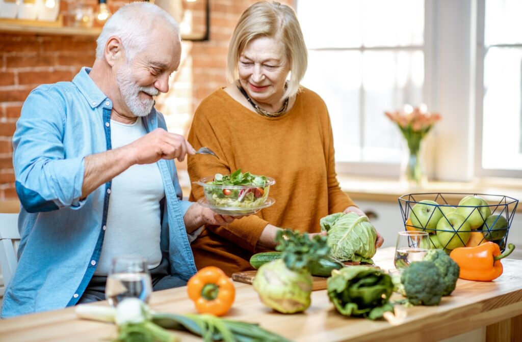 A happy senior couple preparing a nutritious meal together in their kitchen.